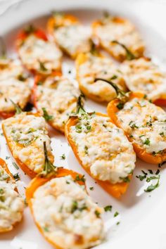 small stuffed peppers with cheese and herbs on a white plate, ready to be eaten