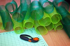 a pair of scissors sitting on top of a piece of paper next to some mesh