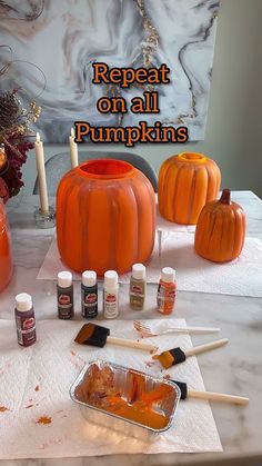 some pumpkins are sitting on a table with paint and other items to decorate them