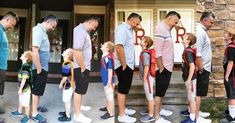 a group of people standing in front of a building with letters on their back legs