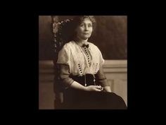 an old black and white photo of a woman in a dress sitting on a chair