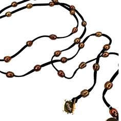 This pearl lariat necklace is made with cinnamon colored freshwater pearls. The brownish color on the black leather is a stunning contrast against black. It wold be nice with animal prints that have black and browns. At 50" long there are many ways to tie it. A linked video shows how to do this but you will see the white pearls in the video. Last phots shows how it looks wrapped multiple times on your wrist as a bracelet. You tie and leave the ends to dangle as a tassel. Elegant Brown Necklace With Adjustable Cord, Adjustable Brown Lariat Necklaces, Adjustable Beaded Brown Lariat Necklace, Adjustable Brown Lariat Necklace, Adjustable Brown Beaded Lariat Necklace, Adjustable Brown Long Lariat Necklace, Brown Adjustable Lariat Necklace, Handmade Brown Lariat Necklace, Elegant Brown Lariat Jewelry