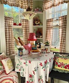 a table with some food on it in front of two window sills and curtains