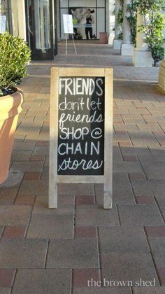 a sign on the sidewalk that says friends don't let friends shop chain stores