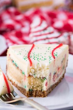 a slice of cake with white frosting and sprinkles on a plate