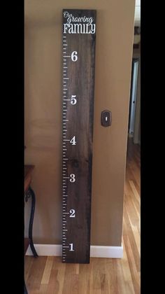 a tall wooden ruler with the words growing family on it's side in front of a door