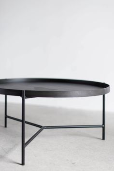 a black coffee table sitting on top of a white floor