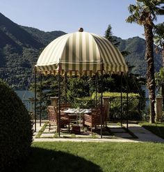 an outdoor gazebo with tables and chairs under it