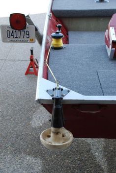 a red and white boat sitting on top of a cement floor next to a sign