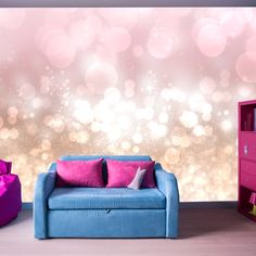 a blue couch sitting in front of a pink wall with lots of lights on it