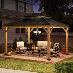 a gazebo with chairs and tables in the yard