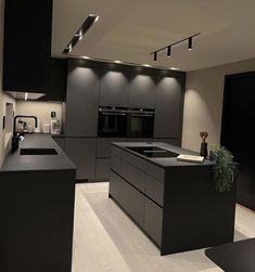 a modern kitchen with black cabinets and counter tops