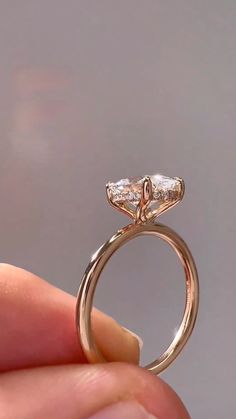 someone is holding a ring with two diamonds on it