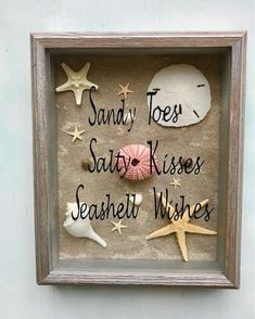 a shadow box with sand, seashells and starfish in it that says sandy toes salty kisses seasidey wishes