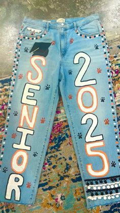 Senior Homecoming Jeans, Senior Parking Spaces Chalk, Senior Jeans Ideas High Schools, Homecoming Jeans Ideas, Senior Painted Jeans, Senior Year Diy, Senior Year Things, Senior Jeans, Senior Year Fun