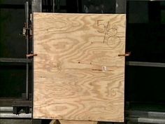 a large piece of wood sitting on top of a wooden floor next to a building