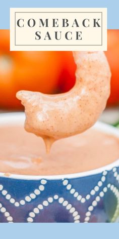 a spoon full of some kind of sauce on top of a blue and white bowl