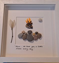 a white frame with some rocks and a leaf in it that says, mum we know you a little more every day