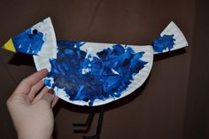 a paper plate bird with blue paint on it