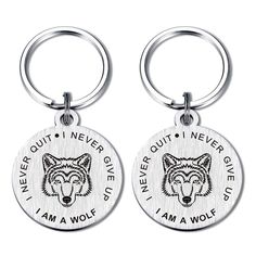 two metal key chains with the words, i am a wolf and an image of a wolf