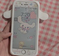 a person holding an iphone with hello kitty stickers on the front and back cover