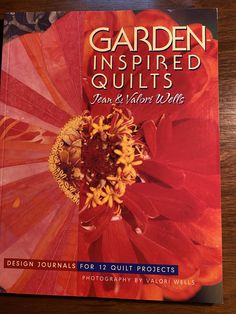 the book garden inspired quilts features an image of a red flower with yellow stamen