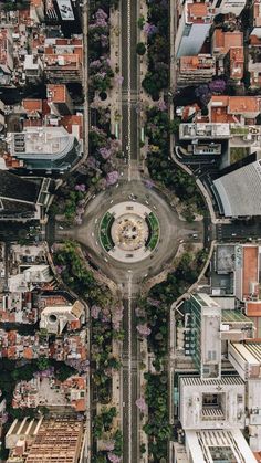 an aerial view of a city with tall buildings and lots of greenery in the middle