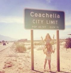 a woman standing in front of a road sign that says coachella city limit pop 4077 elev 11