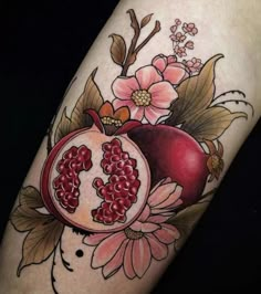 a pomegranate with flowers and leaves on the arm