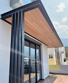 an outdoor patio with sliding glass doors and wooden roof