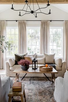 a living room with two couches and a coffee table in front of large windows