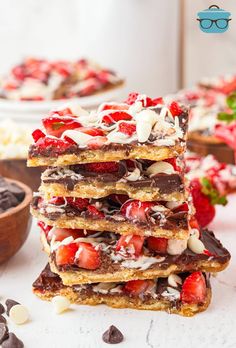 a stack of strawberry shortbreads with chocolate chips and strawberries on the side