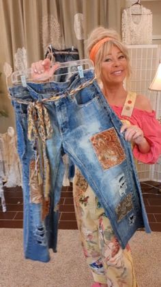 a woman is holding up her jeans in front of the camera