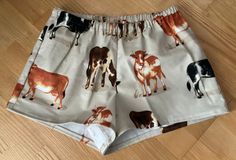 Cows on beige background flannel sleep shorts 100% cotton flannel  Enclosed elastic waistband with 1/2" non-roll elastic Low rise Side seams 2" inseam on all sizes Hip sizing:   XS(32-34"), S(35-37"), M(38-40"), L(41-43") Front rise:  XS(9 3/4"), S(10 1/2"), M(11 1/2"), L(12 3/4") Back rise:  XS(13 1/2"), S(14 1/2"), M(16"), L(16 3/4") Measurements are approximate  Sizing allows for about 2-3 inches of ease/shorts run a size smaller than the pants  All seams are sewn with a serger except for topstitching on waistband and hems. Fabric is not prewashed.  Shrinkage is vertical. Best to wash in cold water separately or with like colors.  Do not soak garment.  Remove promptly into dryer on low heat.  No chlorine bleach. (Shorts run small.) Flannel sleep shorts are not returnable For other impor Cotton Shorts With Elastic Waistband For Pajama Party, Cotton Pajama Shorts With Elastic Waistband For Bedtime, Casual Pajama Shorts With Elastic Waistband For Bedtime, Casual Pajama Shorts For Bedtime, Sleepover Pajama Shorts With Elastic Waistband, Pajama Shorts With Elastic Waistband For Bedtime, Relaxed Fit Shorts With Elastic Waistband For Bedtime, Elastic Waistband Pajama Shorts For Bedtime, Relaxed Fit Bedtime Shorts With Elastic Waistband