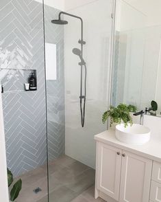 a bathroom with a walk in shower next to a white sink and counter top under a mirror