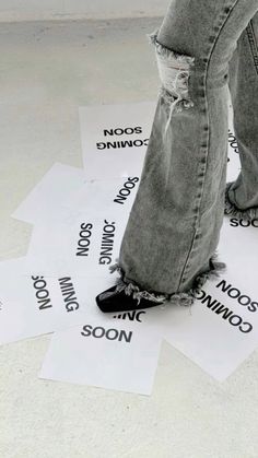 someone is standing on some paper that has words written on it and their feet are sticking out