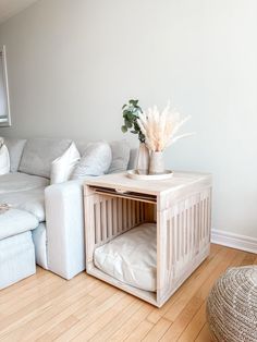 a white couch sitting next to a wooden table on top of a hard wood floor