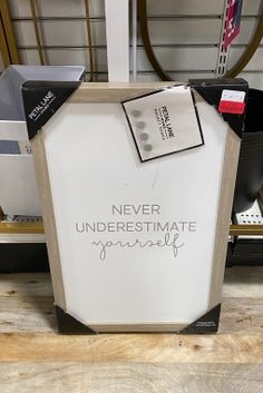 there is a sign that says never underestimate yourself on the side of a shelf