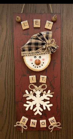 a snowman made out of wood blocks on top of a wooden table with the words let it snow