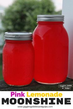 two red mason jars sitting on top of a wooden table next to each other with text overlay reading pink lemonade moonshine