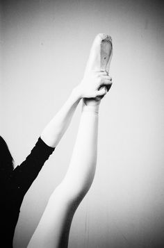 black and white photograph of a woman holding up a banana