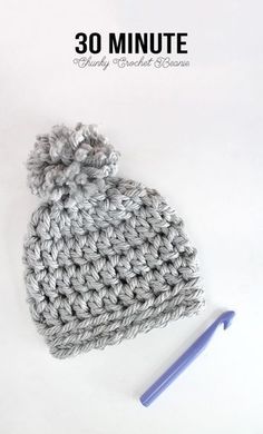 the crochet hat is next to a knitting needle