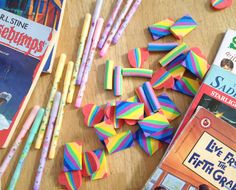 some books and pencils are on a table with other school supplies like pens, paper clips, and magnets