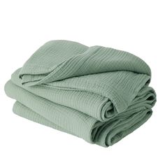 two blankets folded on top of each other, one is green and the other is white