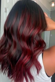 If you're rocking gorgeous black tresses but craving a little extra something, red highlights could be what you need. A few flashes of fiery crimson or bright ruby red can instantly amp up the drama and add mega dimension to your dark strands. Whether you want a subtle burgundy glaze… Brown Hair With Black And Red Highlights, Dark Red With Bright Red Highlights, Red Streaked Hair Highlights, Red Cherry Highlights On Black Hair, Dark Hair Red Streaks, Two Strand Hair Dye, Dark Copper Hair With Dark Roots, Cherry Red With Highlights, Balayage Hair With Red