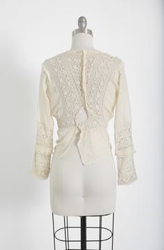 "Stunning Antique vintage early 1900's Edwardian crochet blouse Floral embroidered crochet lace, high neck long sleeve Natural cotton in ivory / cream button down back Great vintage condition - few age spots (see photos) very wearable M e a s u r e m e n t s: Size: fits like a XS S BUST: 18 1/2\" Waist: 13\" Total Length: 22\" Sleeves: 20\" Label: unbranded Fabric: cotton +All Measurements are taking while garment is lying flat+ + Jewelry, belts, and any other accessories are NOT included unless Victorian Long Sleeve Blouse For Vintage Fashion, Long Sleeve Cotton Crochet Top With Lace Trim, Long Sleeve Crochet Cotton Top With Lace Trim, Cotton Crochet Top With Lace Trim, Fitted Vintage Cotton Lace Tops, Fitted Cotton Lace Blouse With Lace Trim, Fitted Long Sleeve Lace Crochet Top, Elegant Long Sleeve Crochet Top With Lace Patchwork, Fitted Lace Crochet Top With Long Sleeves