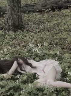 a woman laying in the grass with her head down