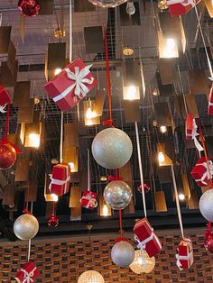 christmas decorations hanging from the ceiling in a room filled with lights and presents on sticks