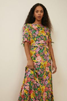 Bold blooms take centre stage in this floral midi dress. Designed with a crew neck and tie detail sleeves, plus a flowing, feminine silhouette. Dress up or down for maximum wearabilty. Model wears a size 8 and is 5'7. Silhouette Dress, Oasis Dress, Oasis Fashion, Centre Stage, Feminine Silhouette, Tie Sleeve, Printed Midi Dress, Floral Midi Dress, Fashion Face