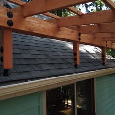 the roof of a house with wood beams and shingles